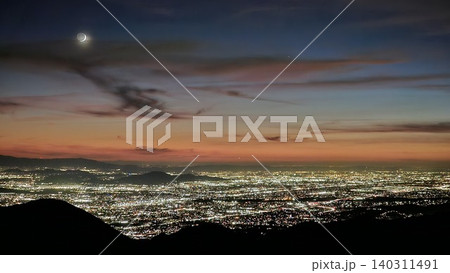 Beautiful Orange, Yellow and Blue Sunset with Moon over the City Lights of San Bernardino Beautiful Orange, Yellow and Blue Sunset with Moon over the City Lights of San Bernardino 140311491