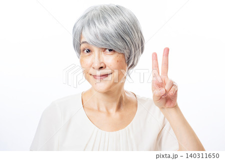 ピースをして満足気に微笑む白髪のシニア女性 ピースをして満足気に微笑む白髪のシニア女性 140311650