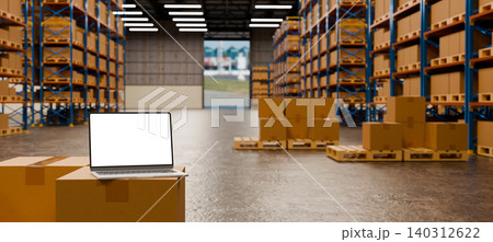 Laptop on cardboard boxes in warehouse with shelves and pallets, logistics and inventory management concept with mockup screen 140312622