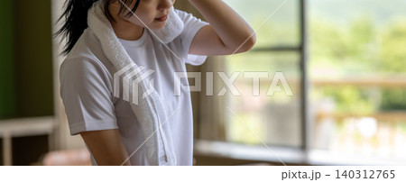 汗を拭う若い女性 140312765
