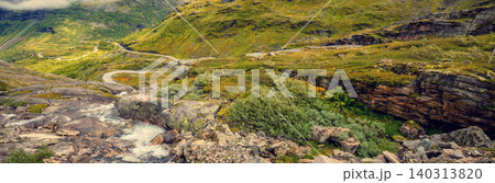 Autumn mountain landscape in Norway. Winding road in the mountains. Road 63 to Geiranger. View from Upper Blaafjeld Bridge Autumn mountain landscape in Norway. Winding road in the mountains. Road 63 to Geiranger. View from Upper Blaafjeld Bridge 140313820