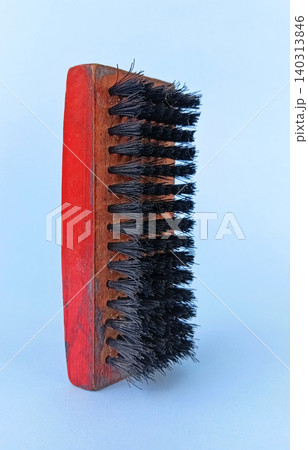 Black and red shoe polish brush on a blue background. Selective focus 140313846