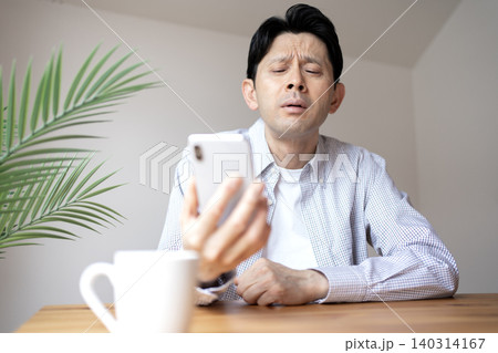 老眼でスマホの画面が見にくいミドル男性 老眼でスマホの画面が見にくいミドル男性 140314167