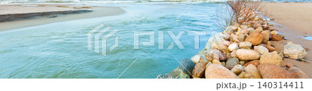 Delta in the daytime. Rocky bank of river. The river flows into the sea Delta in the daytime. Rocky bank of river. The river flows into the sea 140314411