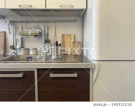 Kitchen appliances near the sink with room lamp lighting Kitchen appliances near the sink with room lamp lighting 140315218