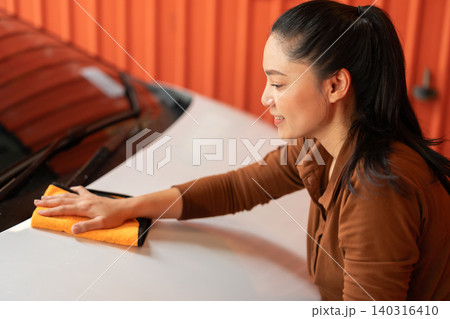 woman washing car with microfiber cloth in a self-service car wash station woman washing car with microfiber cloth in a self-service car wash station 140316410
