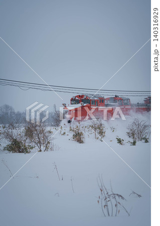 雪の中を走る赤いラッセル車 140316929