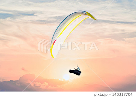 Paragliding, an adventure sport, free flight in nature under an orange sky at sunset. Sant Llorenc de Montgai, Noguera region, Lleida, Catalonia. Paragliding, an adventure sport, free flight in nature under an orange sky at sunset. Sant Llorenc de Montgai, Noguera region, Lleida, Catalonia. 140317704