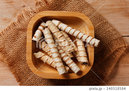 Crispy wafer sticks filled with chocolate cream served in a small rustic bamboo bowl Crispy wafer sticks filled with chocolate cream served in a small rustic bamboo bowl 140318584