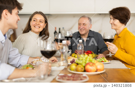 Girl enjoying family dinner with husband and parents-in-law 140321808