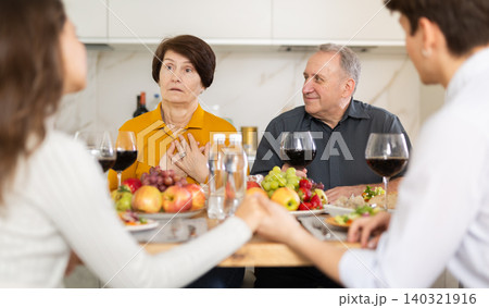 Happy family having dinner together at festive table at home 140321916