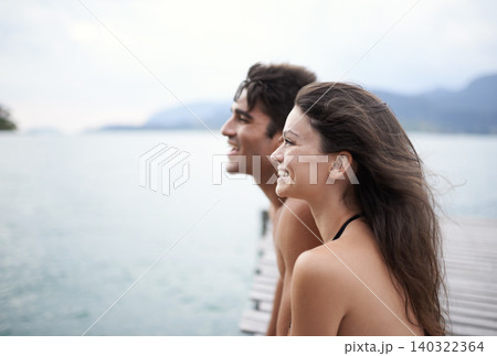Couple, jetty and travel to ocean on adventure, love and relax by water on summer holiday. People, swimwear and bonding for relationship in outdoor, support and smile on weekend trip to sea or nature Couple, jetty and travel to ocean on adventure, love and relax by water on summer holiday. People, swimwear and bonding for relationship in outdoor, support and smile on weekend trip to sea or nature 140322364