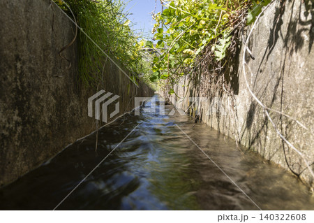 農業用コンクリート水路を流れる水のローアングルクローズアップ 農業用コンクリート水路を流れる水のローアングルクローズアップ 140322608