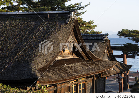 茅葺き屋根の神社社殿と湖の風景 140322665