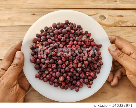 Hand holding plate filled with fresh phalsa seasonal fruit of Pakistan Hand holding plate filled with fresh phalsa seasonal fruit of Pakistan 140322971