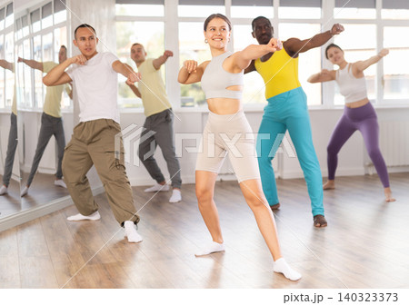Young woman practicing Capoeira dance in training hall Young woman practicing Capoeira dance in training hall 140323373