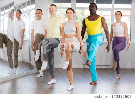 Young and middle-aged men and women practicing Irish dance in training hall Young and middle-aged men and women practicing Irish dance in training hall 140323607