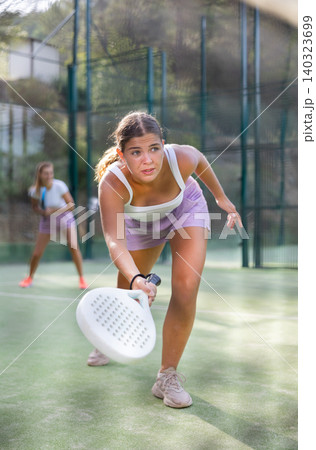Young woman padel tennis player trains on the outdoor court Young woman padel tennis player trains on the outdoor court 140323699