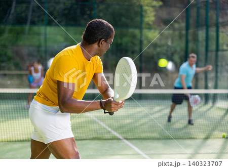 African american man padel tennis player trains on the court African american man padel tennis player trains on the court 140323707