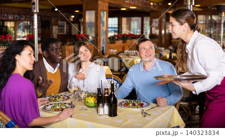 Group of friends makes an order waitress during a dinner in restaurant Group of friends makes an order waitress during a dinner in restaurant 140323834