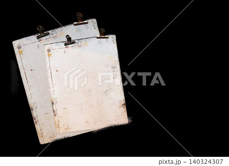 Aged clipboards with visible wear and patina are layered diagonally against a solid black background Aged clipboards with visible wear and patina are layered diagonally against a solid black background 140324307