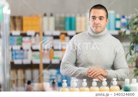 Portrait of man in winter clothes shopper choosing some products in supermarket Portrait of man in winter clothes shopper choosing some products in supermarket 140324600