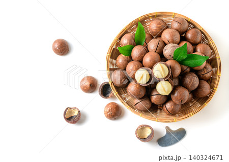 Top View of Macadamia Nuts in Wicker Basket with Cracked Shells and Kernels Isolated on White Background Top View of Macadamia Nuts in Wicker Basket with Cracked Shells and Kernels Isolated on White Background 140324671