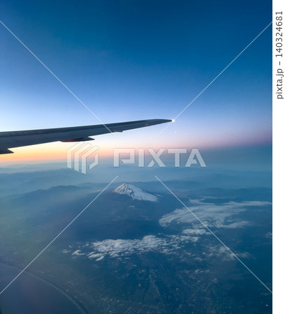 飛行機の窓から見た夕暮れの富士山と空 140324681