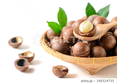 Macadamia Nut Kernel on Wooden Spoon with Basket of Whole Nuts Isolated on White Background Macadamia Nut Kernel on Wooden Spoon with Basket of Whole Nuts Isolated on White Background 140324735