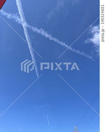 青空に描かれたクロスする二本の飛行機雲 140324881