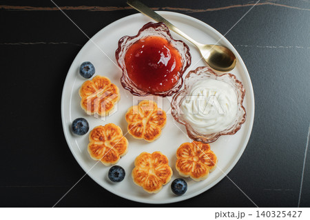 Cottage cheese pancakes, syrniki, curd fritters decorated with strawberry and raspberry served on a white plate. Homemade breakfast concept 140325427