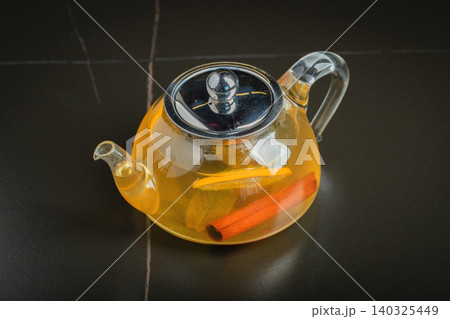 Fruit tea with mango and mint in a glass teapot on the table Fruit tea with mango and mint in a glass teapot on the table 140325449