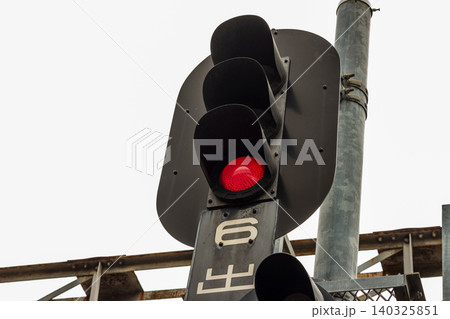 6出(6番線出発)の文字札が付いた鉄道の3灯式出発信号機(赤信号・停止現示) 6出(6番線出発)の文字札が付いた鉄道の3灯式出発信号機(赤信号・停止現示) 140325851