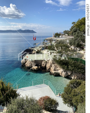 Scenic coastal view with clear blue water and rocky surroundings under a bright sky 140326857