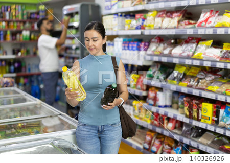 Buyer view assortment, woman choose vegetable oil 140326926