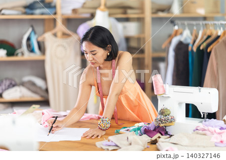 Young woman seamstress draws sketch on paper Young woman seamstress draws sketch on paper 140327146