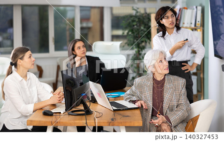 Group of women watching presentation in office Group of women watching presentation in office 140327453