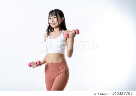 ダンベルを持ち上げ体を鍛える女性 ダンベルカール 筋トレ女子 斜め ダンベルを持ち上げ体を鍛える女性 ダンベルカール 筋トレ女子 斜め 140327708