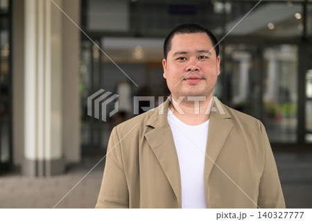 Confident plus size Isan Thai businessman at office entrance horizontal Confident plus size Isan Thai businessman at office entrance horizontal 140327777