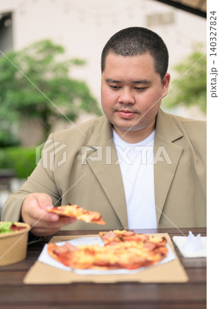 Plus size Isan Thai businessman eating pizza at outdoor cafe vertical 140327824