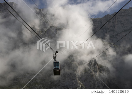 Cable car in front of a foggy mountain 140328639