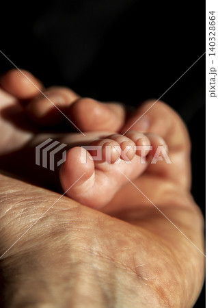 Father hand holding a baby foot 140328664