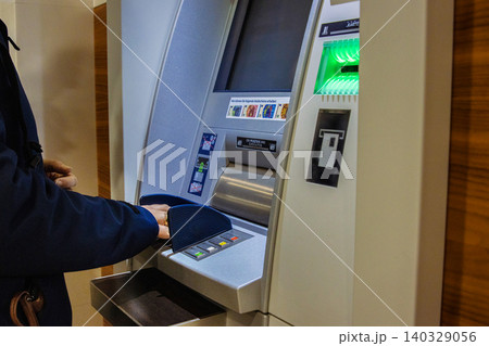 Closeup of person hand entering pin on a concealed atm keyboard. Secure keypad of cash machine. Confidentiality, privacy, reliability, security, and and secure banking concept Closeup of person hand entering pin on a concealed atm keyboard. Secure keypad of cash machine. Confidentiality, privacy, reliability, security, and and secure banking concept 140329056