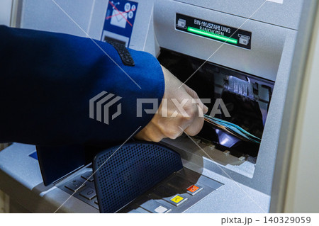 Closeup of a person withdrawing cash from an atm. Customer taking banknotes from an cash machine, symbolizing digital finance, personal banking, and financial management in the modern economy. Closeup of a person withdrawing cash from an atm. Customer taking banknotes from an cash machine, symbolizing digital finance, personal banking, and financial management in the modern economy. 140329059