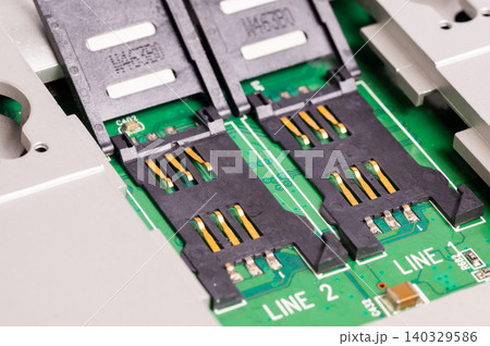 Close-up of dual SIM card slots on an electronic circuit board. Mobile communication hardware component used in smartphones, routers, and telecommunication devices. Close-up of dual SIM card slots on an electronic circuit board. Mobile communication hardware component used in smartphones, routers, and telecommunication devices. 140329586