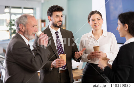 Multiage colleagues chat and laugh during coffee break Multiage colleagues chat and laugh during coffee break 140329889