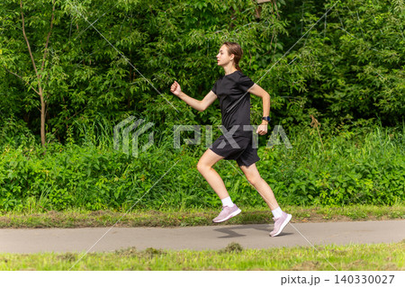 Young woman jogging on a park path Young woman jogging on a park path 140330027