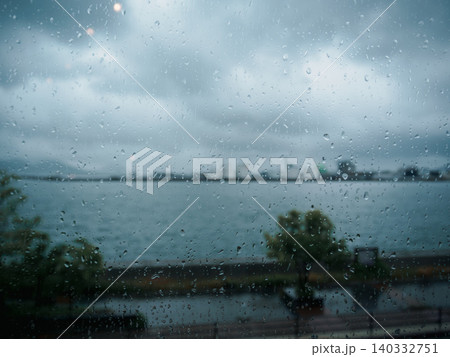 雨粒がついた窓ガラス越しの風景 雨粒がついた窓ガラス越しの風景 140332751