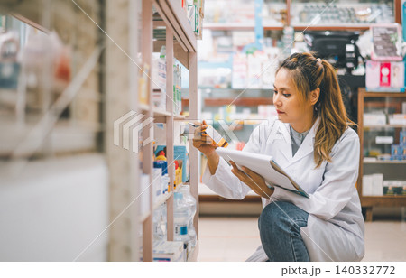 Pharmacist checking Checks Inventory of Medicine, Drugs, Vitamins with tablet and checking patient's prescription in modern pharmacy. Pharmacist checking Checks Inventory of Medicine, Drugs, Vitamins with tablet and checking patient's prescription in modern pharmacy. 140332772