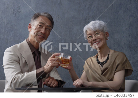 ウィスキーを飲むシニアの夫婦 乾杯 黒背景 ウィスキーを飲むシニアの夫婦 乾杯 黒背景 140333457